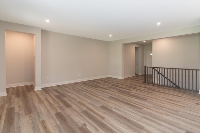 spare room featuring recessed lighting, wood finished floors, and baseboards