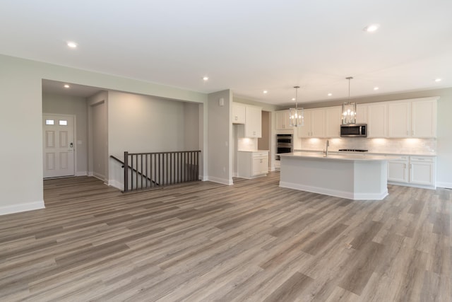 kitchen with stainless steel appliances, recessed lighting, light wood-style flooring, white cabinetry, and tasteful backsplash