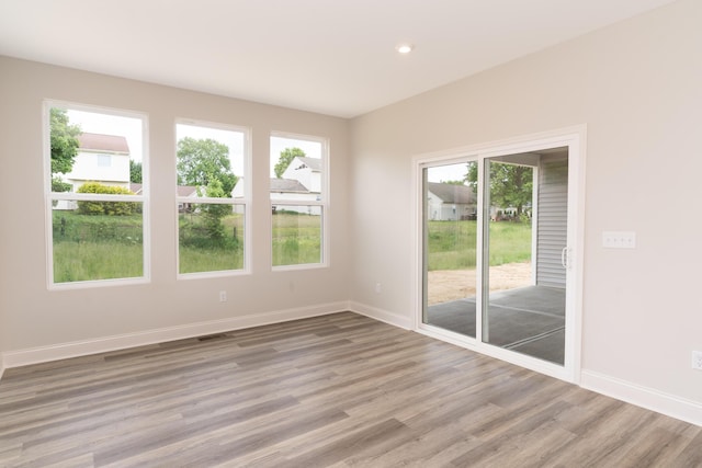unfurnished room with wood finished floors, baseboards, and recessed lighting