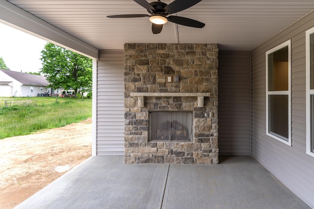 view of patio with an outdoor stone fireplace and a ceiling fan