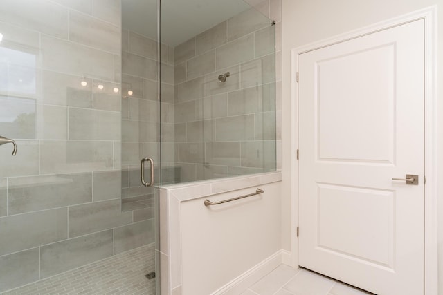 bathroom featuring a stall shower, tile patterned floors, and baseboards