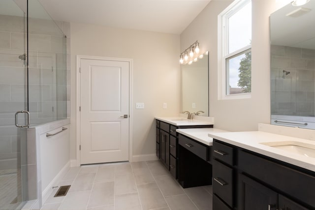 full bath with a shower stall, two vanities, tile patterned flooring, and baseboards