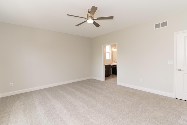empty room featuring ceiling fan, light carpet, and baseboards