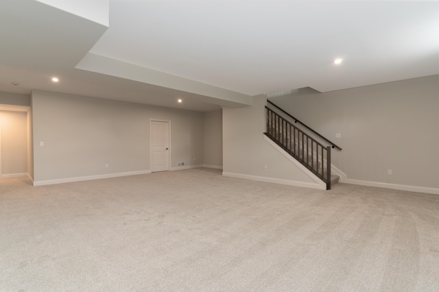 unfurnished living room with recessed lighting, light carpet, stairway, and baseboards