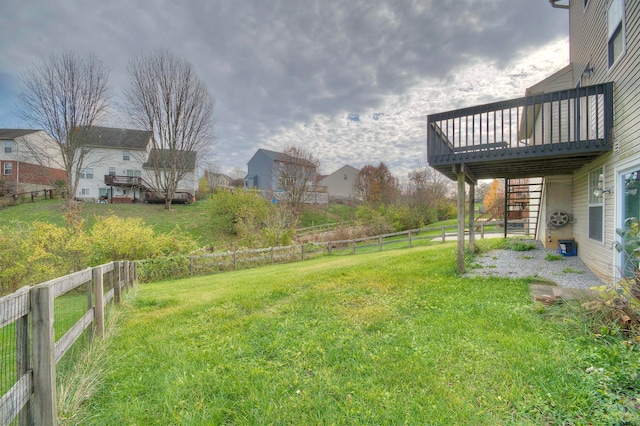 view of yard featuring a fenced backyard, a deck, and stairs