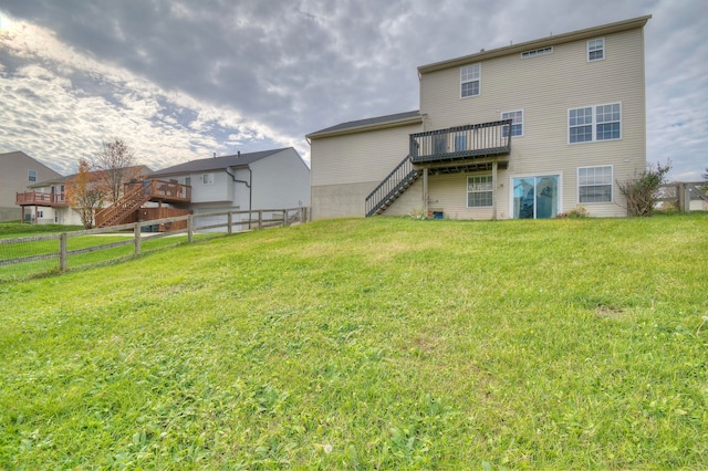 back of house featuring a fenced backyard, a yard, a wooden deck, and stairs