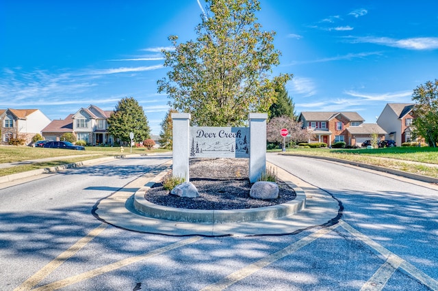 view of road featuring traffic signs, a residential view, and curbs