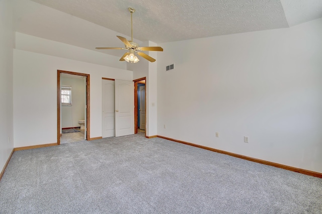 unfurnished bedroom with carpet floors, visible vents, baseboards, and vaulted ceiling