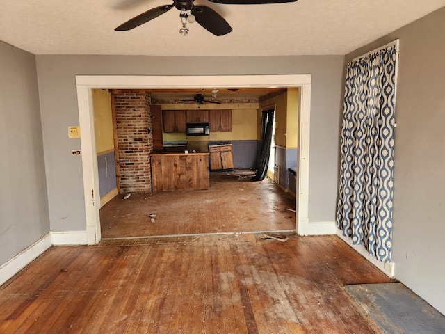 unfurnished living room with dark hardwood / wood-style floors and ceiling fan