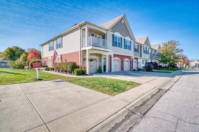 multi unit property featuring driveway, brick siding, a front yard, and a balcony