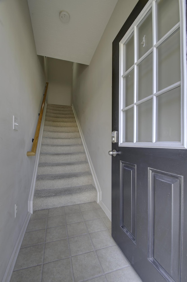 stairs featuring baseboards and tile patterned floors