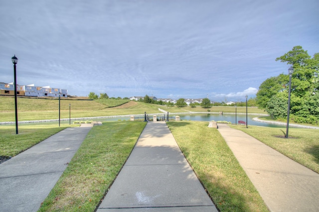 view of community with a lawn and a water view