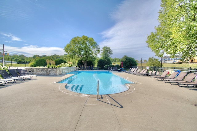 pool with a patio area and fence