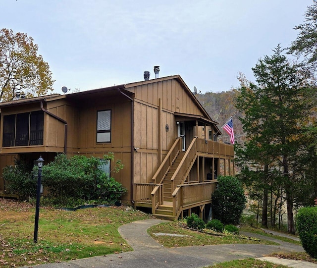 exterior space featuring board and batten siding, stairway, and a wooden deck