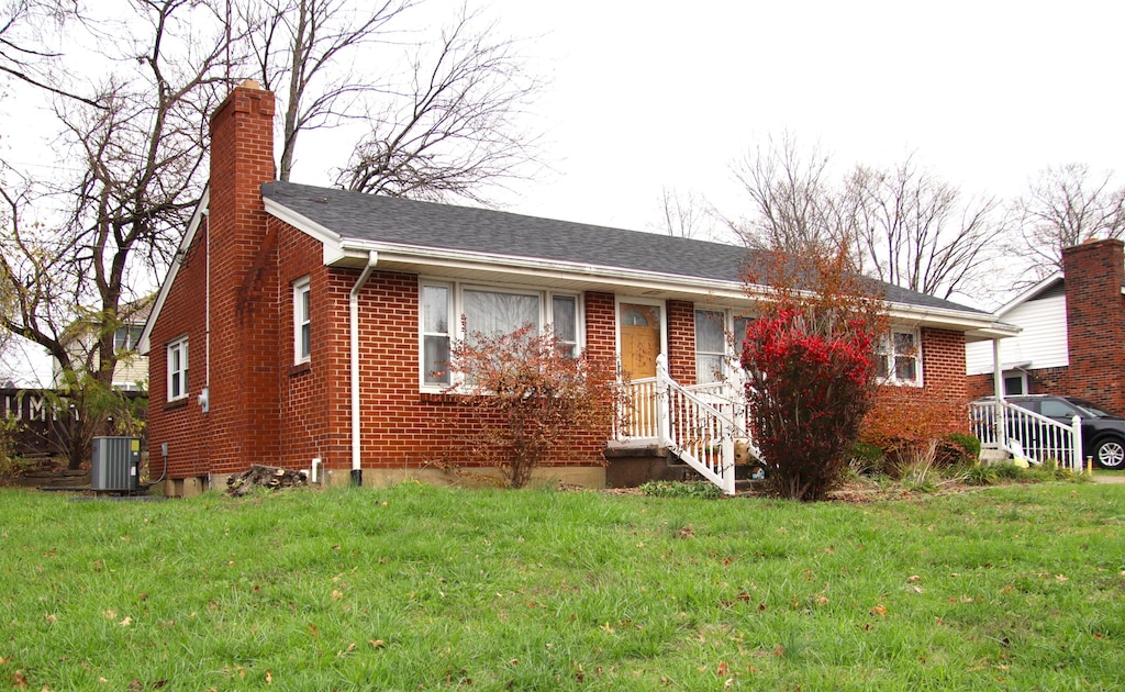 single story home with cooling unit and a front lawn