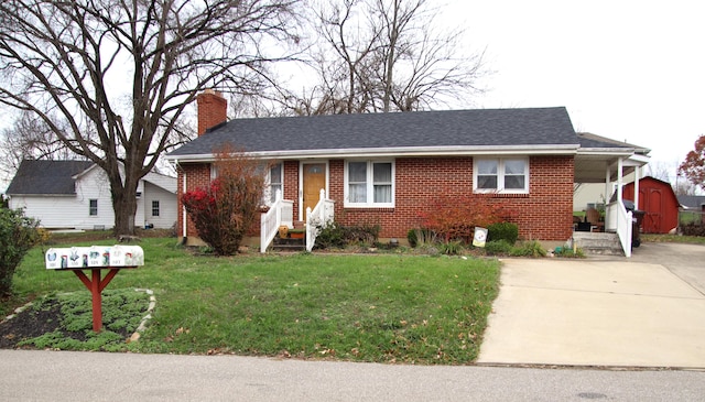 view of front of property featuring a front yard and a storage shed