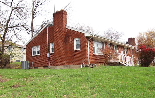 view of side of home featuring central AC and a lawn