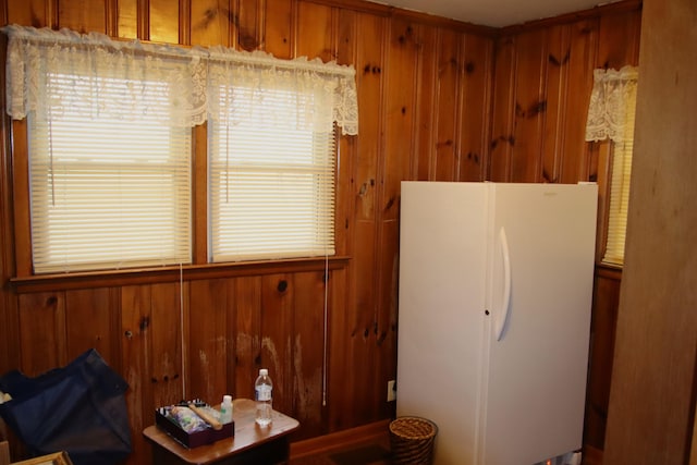 kitchen featuring white refrigerator and wooden walls