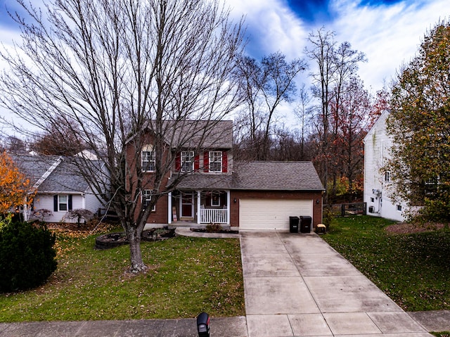 view of front of home with a front yard, a porch, and a garage