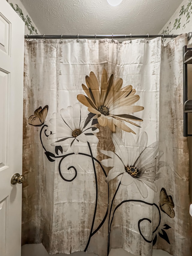 bathroom with a textured ceiling and curtained shower