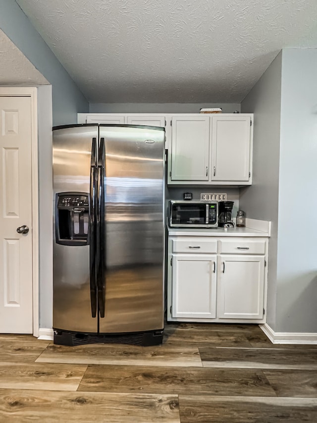 kitchen featuring dark wood-type flooring, white cabinets, and stainless steel appliances