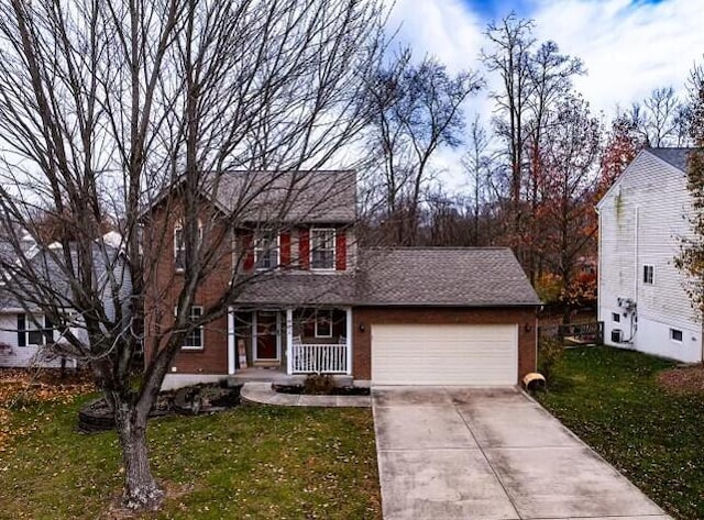 10258 Cardigan Dr, Union, KY 41091 - view of front of property featuring a front yard, a porch, an attached garage, a shingled roof, and concrete driveway