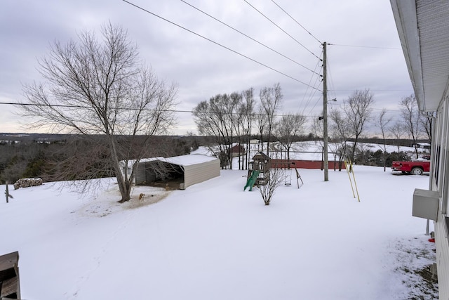 yard layered in snow featuring a playground