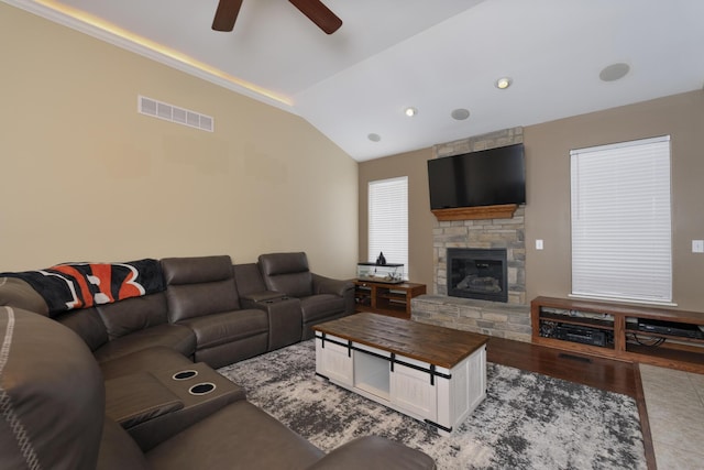 living room with lofted ceiling, a fireplace, ceiling fan, and light wood-type flooring