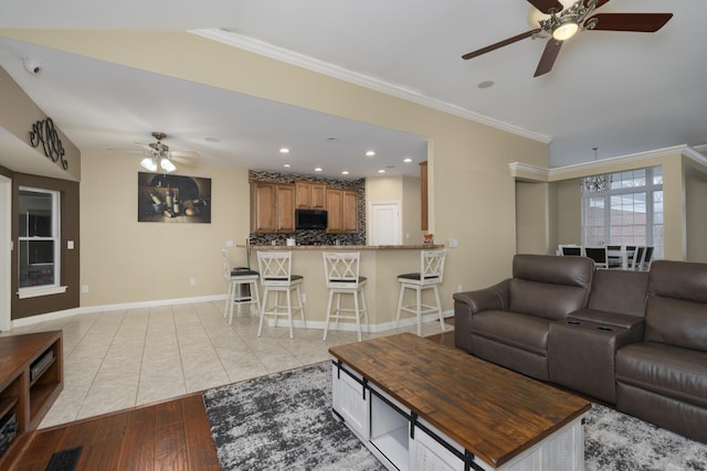 living room featuring ornamental molding, ceiling fan, and light wood-type flooring