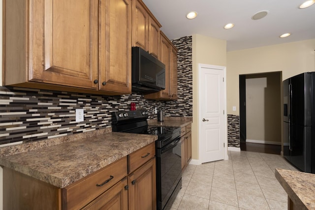 kitchen featuring light tile patterned floors, decorative backsplash, and black appliances