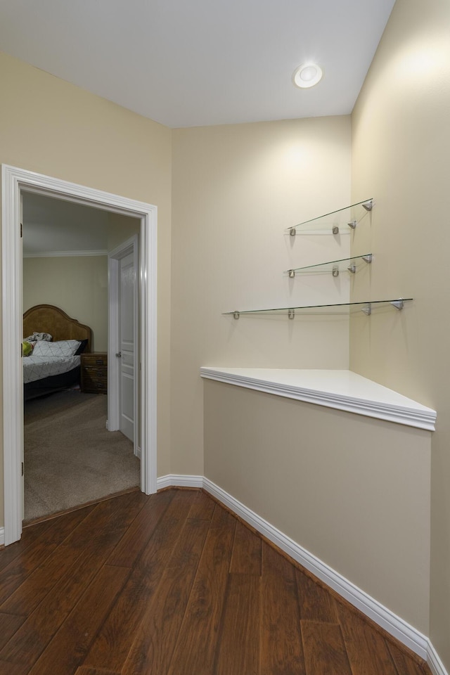 hall featuring baseboards and dark wood-style floors