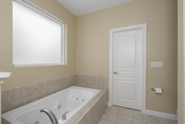 bathroom featuring tile patterned floors, baseboards, and a tub with jets