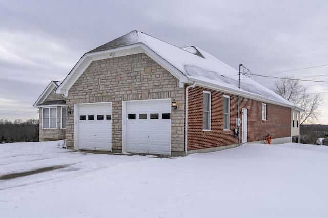 view of snow covered exterior featuring a garage