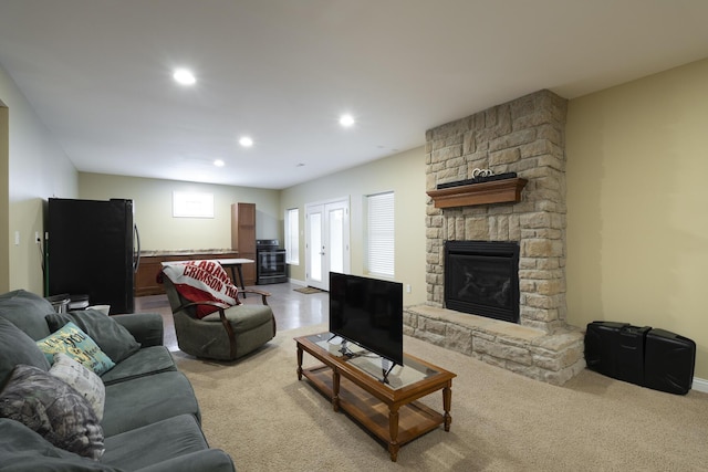 living room featuring french doors, light colored carpet, and a fireplace