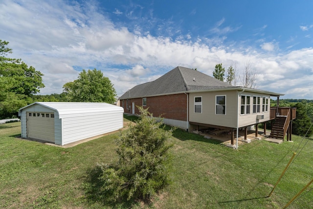 view of side of property with an outbuilding, a garage, a yard, and a deck