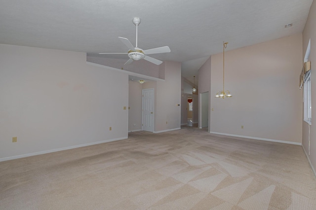 unfurnished living room with ceiling fan with notable chandelier, high vaulted ceiling, and light carpet