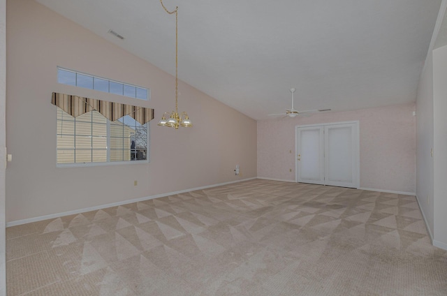 empty room featuring high vaulted ceiling, light colored carpet, and ceiling fan with notable chandelier