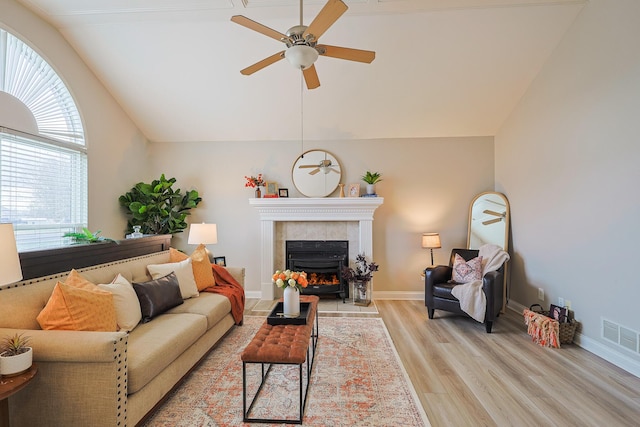 living room featuring ceiling fan, vaulted ceiling, and light wood-type flooring