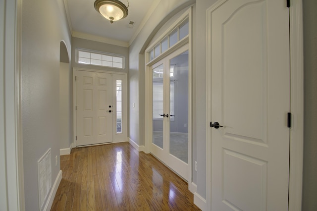 foyer entrance with french doors, light hardwood / wood-style floors, and ornamental molding