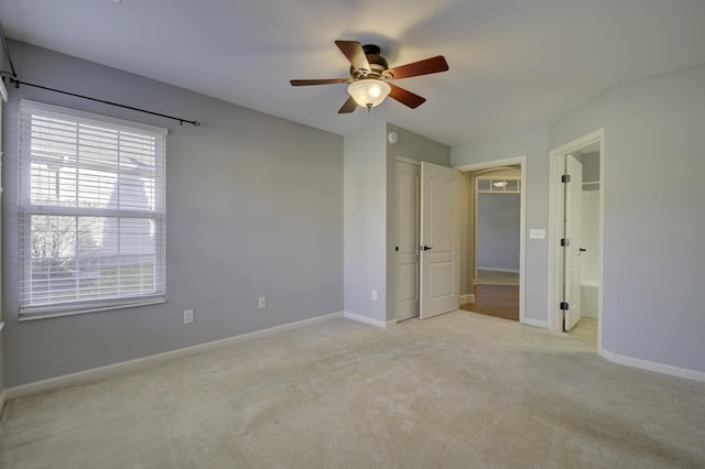 unfurnished bedroom with connected bathroom, ceiling fan, a closet, and light colored carpet