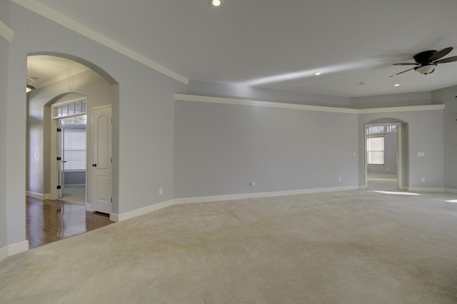 carpeted empty room with ceiling fan and ornamental molding