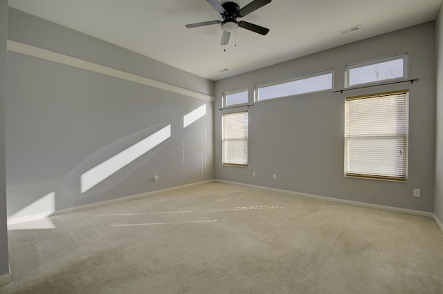 empty room featuring ceiling fan and light colored carpet