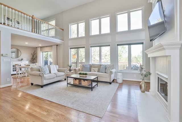 living room with light hardwood / wood-style flooring and a high ceiling