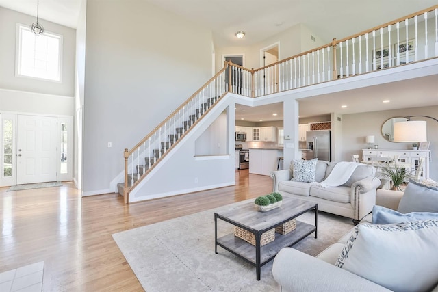 living room featuring a towering ceiling and light hardwood / wood-style floors