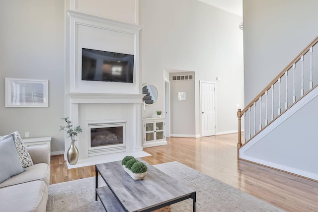 living room with light hardwood / wood-style floors and a high ceiling