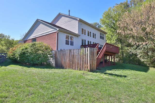 back of property featuring a yard and a wooden deck