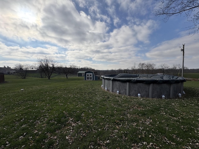 view of yard with a covered pool, an outdoor structure, and a storage shed