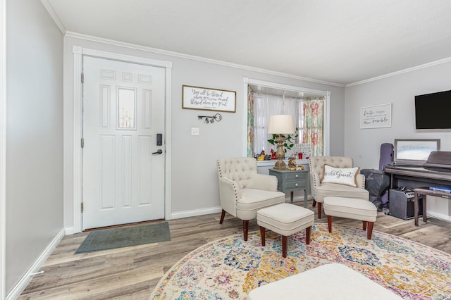 living area featuring baseboards, light wood finished floors, and crown molding