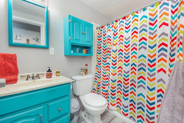 bathroom featuring curtained shower, vanity, toilet, and a textured ceiling