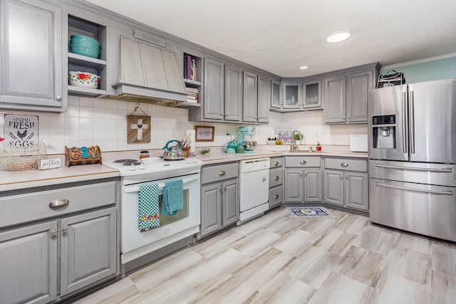 kitchen with gray cabinetry, premium range hood, white appliances, light countertops, and open shelves